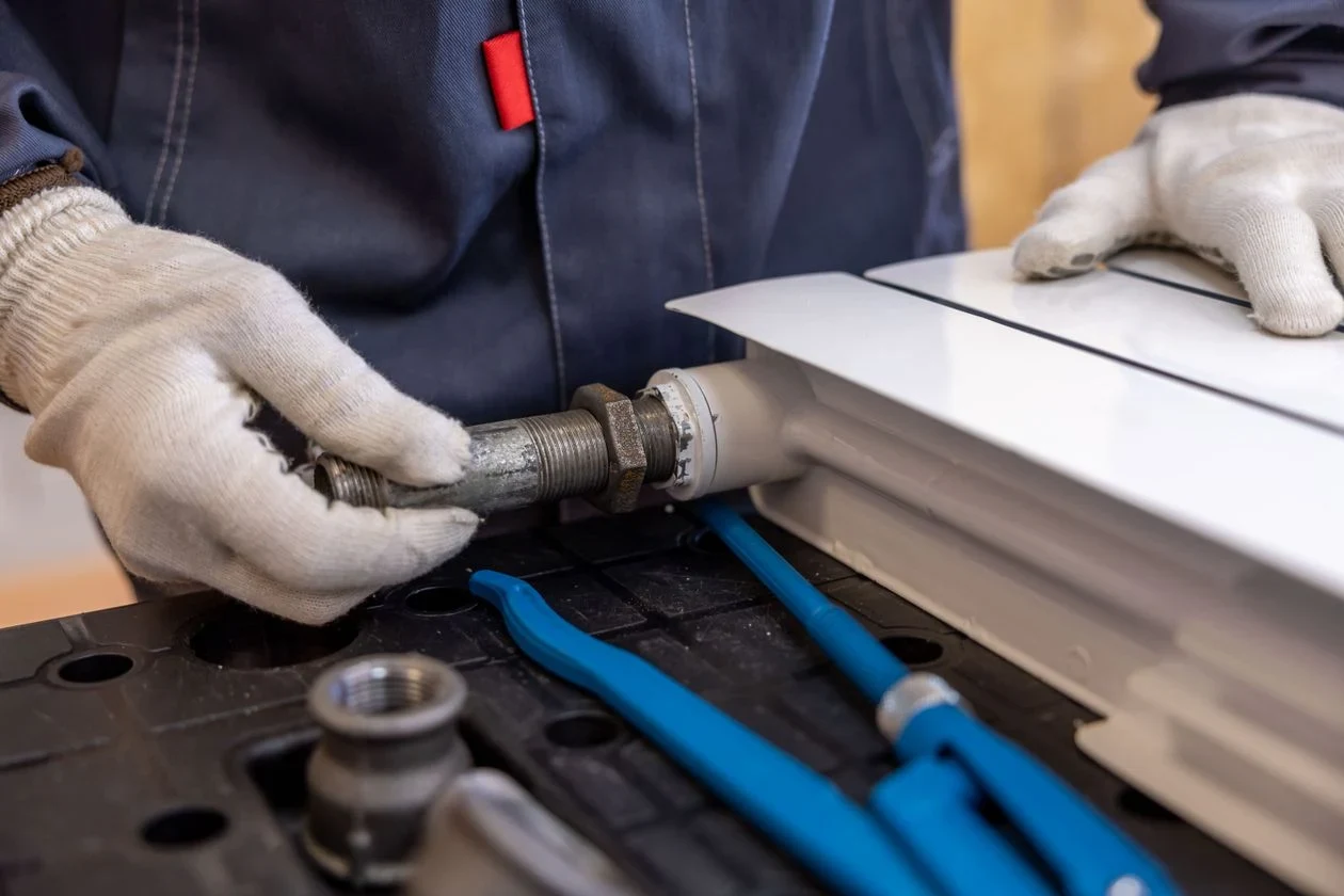 Technician fitting a new valve connection with gloved hands