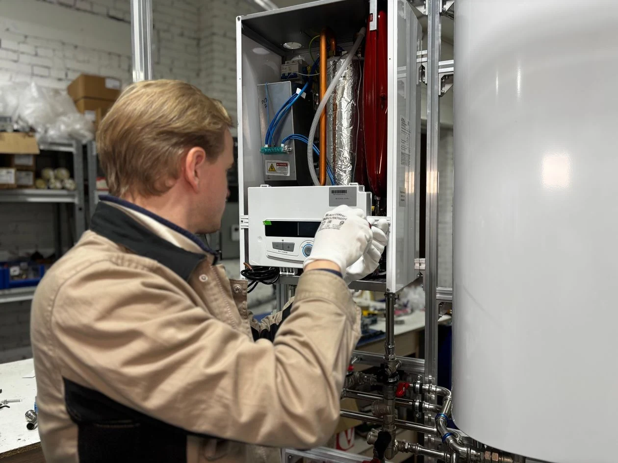 Technician servicing a wall mounted tankless water heater